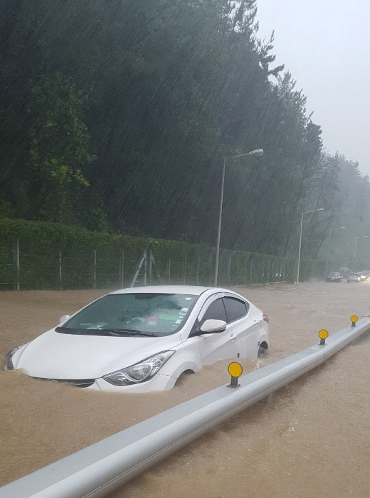 [포토] 태풍 속 물에 잠긴 채 운행하는 승용차