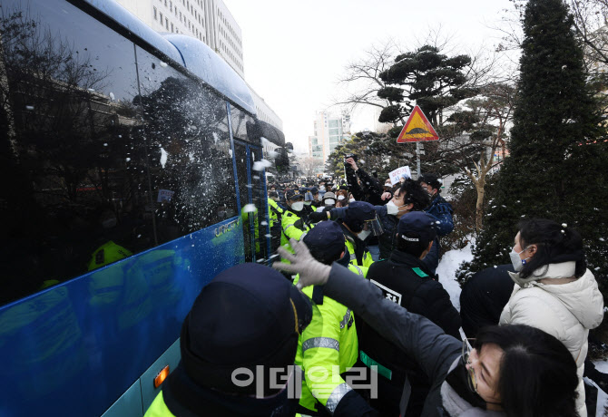 [포토]호송 버스를 향해 눈 던지는 시민