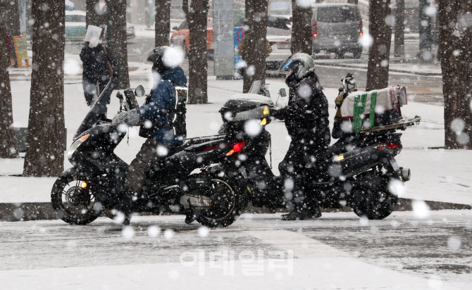 [포토]폭설로 눈 쌓인 도로…오토바이도 '조심조심'