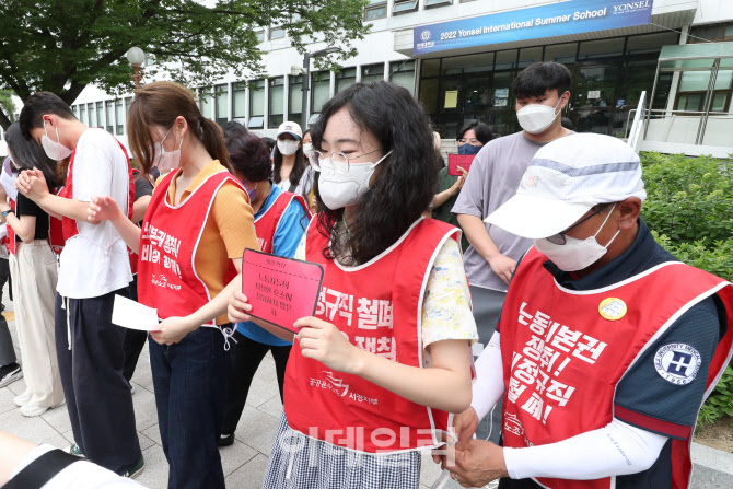 [포토]연세대 재학생에게 투쟁 옷을 입혀주는 청소경비노동자