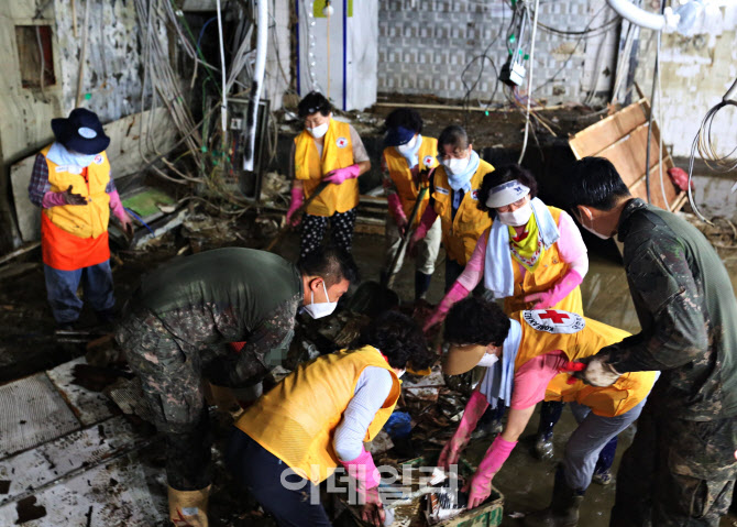 [포토]침수 피해 지역에서 복구활동하는 적십자 봉사원