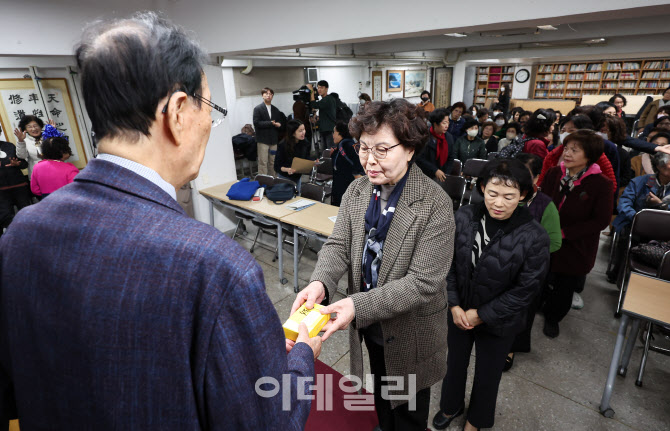 [포토]교장선생님게 합격 떡 전달받는 만학도들