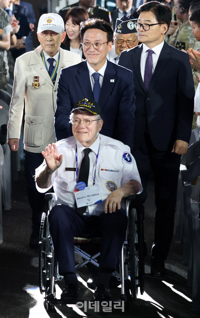 [포토]참전용사 휠체어 밀고 같이 입장하는 김민석 총리