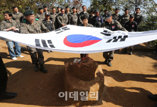 [포토]발굴유해에 태극기 덮는 박근혜