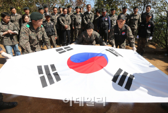 [포토]발굴유해에 태극기 덮는 박근혜