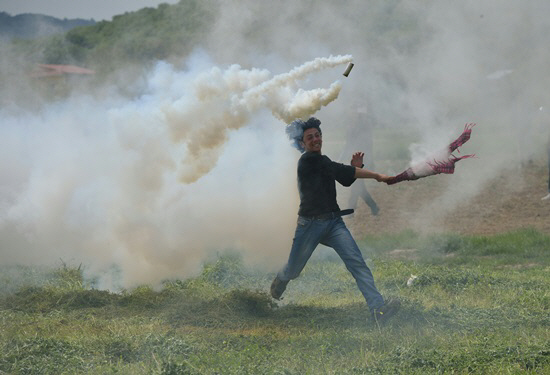 경찰이 던진 최루탄에 맞은 그리스 난민                                                                                                                                                             