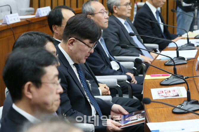 [포토]'제 3차 청문회', 책상 밑에서 의혹사진을 다시금 확인하는 김영재 원장