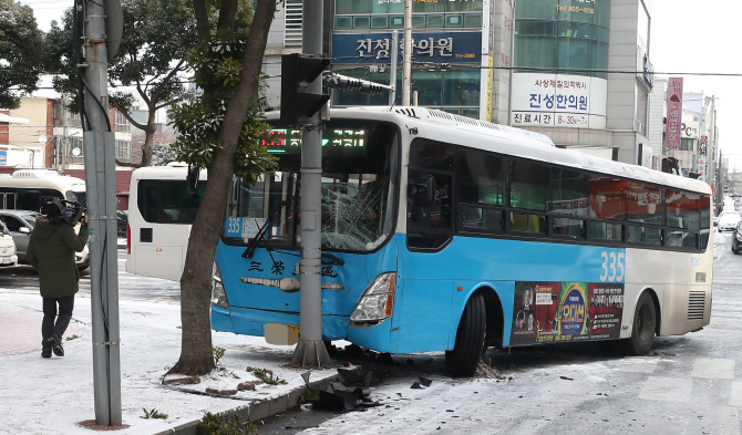 [포토] 눈길에 미끄러져 신호등 들이받은 버스
