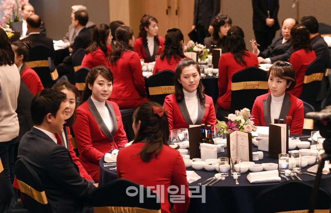 [포토]환영만찬서 대화하는 북한 응원단
