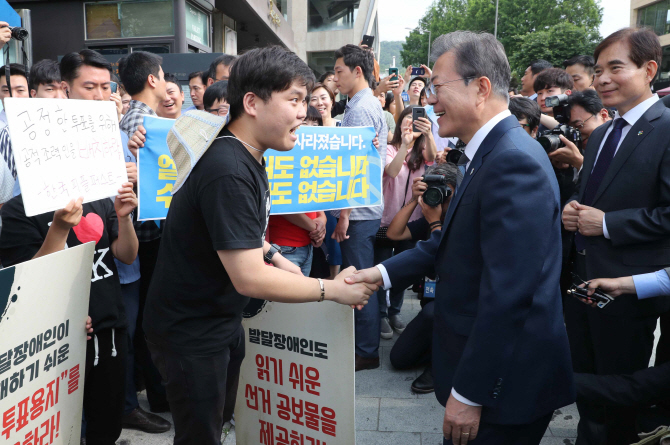 [포토] 문 대통령, 투표소 앞에서 참정권 요구 장애인 단체 만나