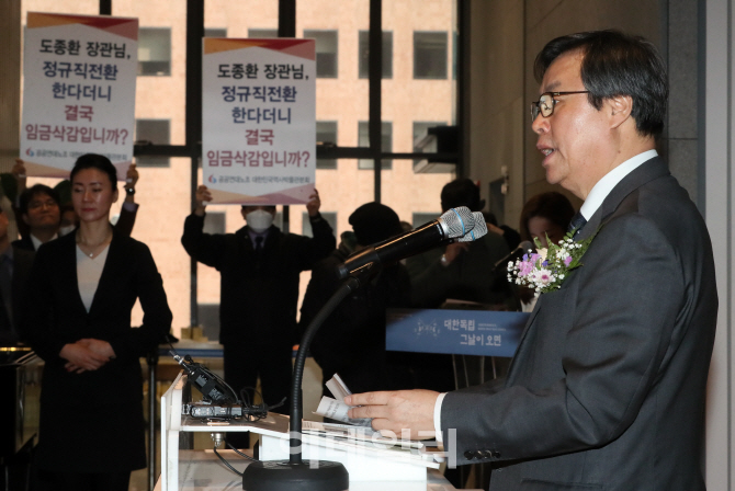 [포토]항의 피켓 옆 축사하는 도종환 문체부 장관