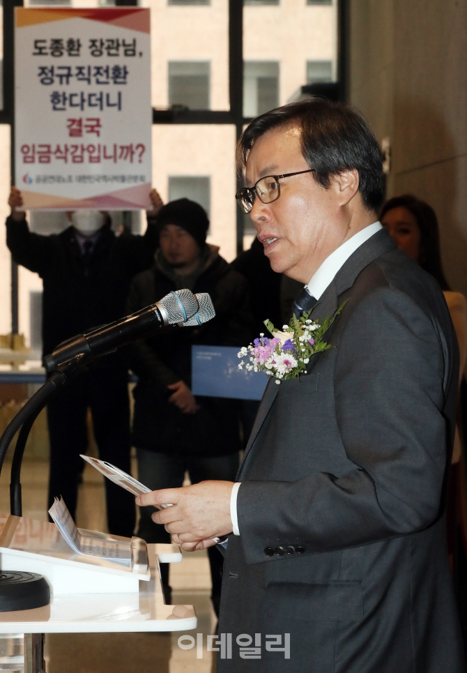 [포토]항의 피켓 옆 축사하는 도종환 문화체육관광부 장관