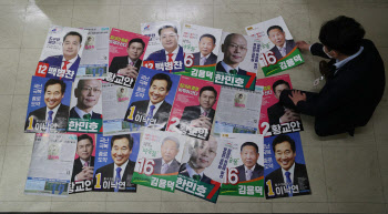 '4.15 총선 D-14' 후보자 선거 벽보 살펴보는 선관위 관계자