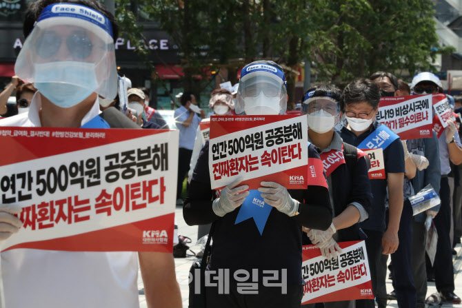 한면 가림막 하고 결의대회 참석한 의료 관계자들                                                                                                                                                    