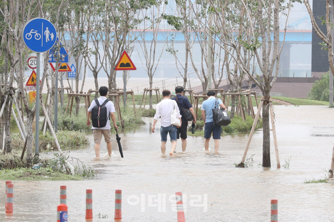 물에 잠긴 한강공원에서 이동하는 관계자들                                                                                                                                                          