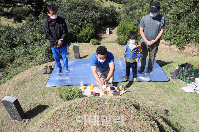 조상님께 술 따르는 한 성묘객                                                                                                                                                                      