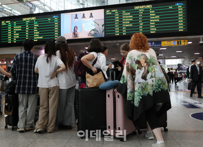  열차 시간표 살펴보는 승객들