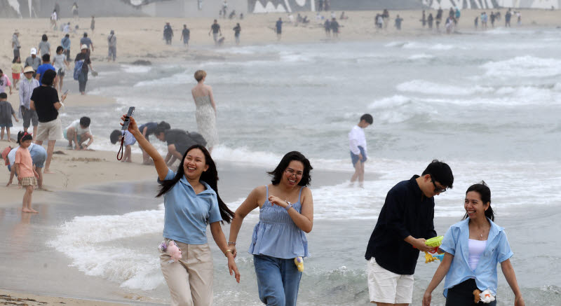 부산해운대해수욕장을 찾은 외국인 관광객들이 해변을 거닐며 활짝 웃고 있다. (사진=뉴스1)