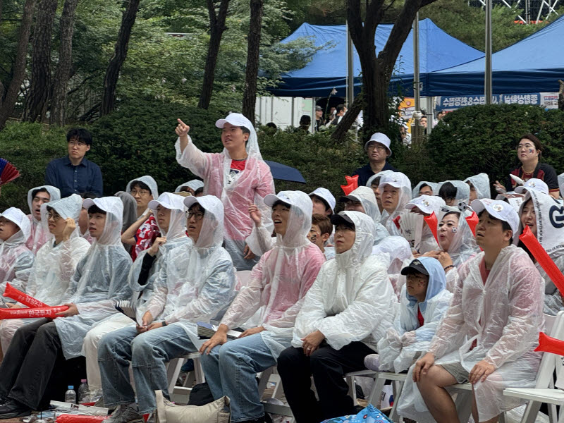 25일 오전 서울 영등포구 여의도에서 시민들이 우비를 입고 남아공전을 지켜보고 있다. (사진=강민혁 수습기자)