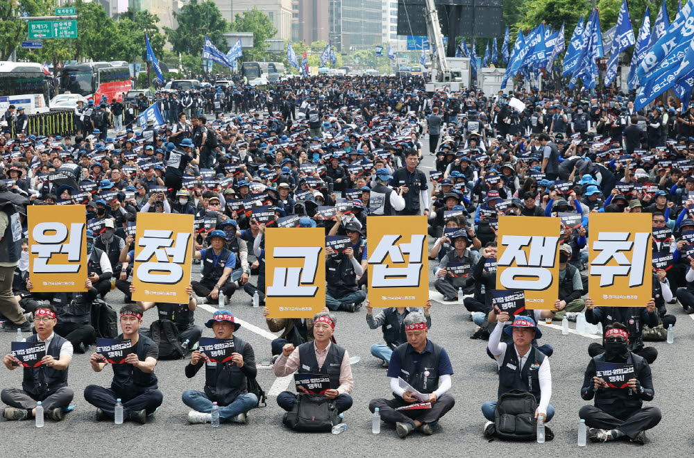 지난달 10일 서울 종로구 광화문광장 인근에서 열린 전국금속노동조합(금속노조) 1만 간부 결의대회에서 참가자들이 손팻말을 들고 있다. (사진=연합뉴스)