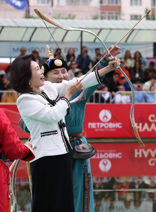 이재명 대통령과 몽골을 국빈 방문 중인 김혜경 여사가 11일(현지시간) 울란바타르 나담축제장에서 전통 활을 쏘고 있다.(사진=연합)