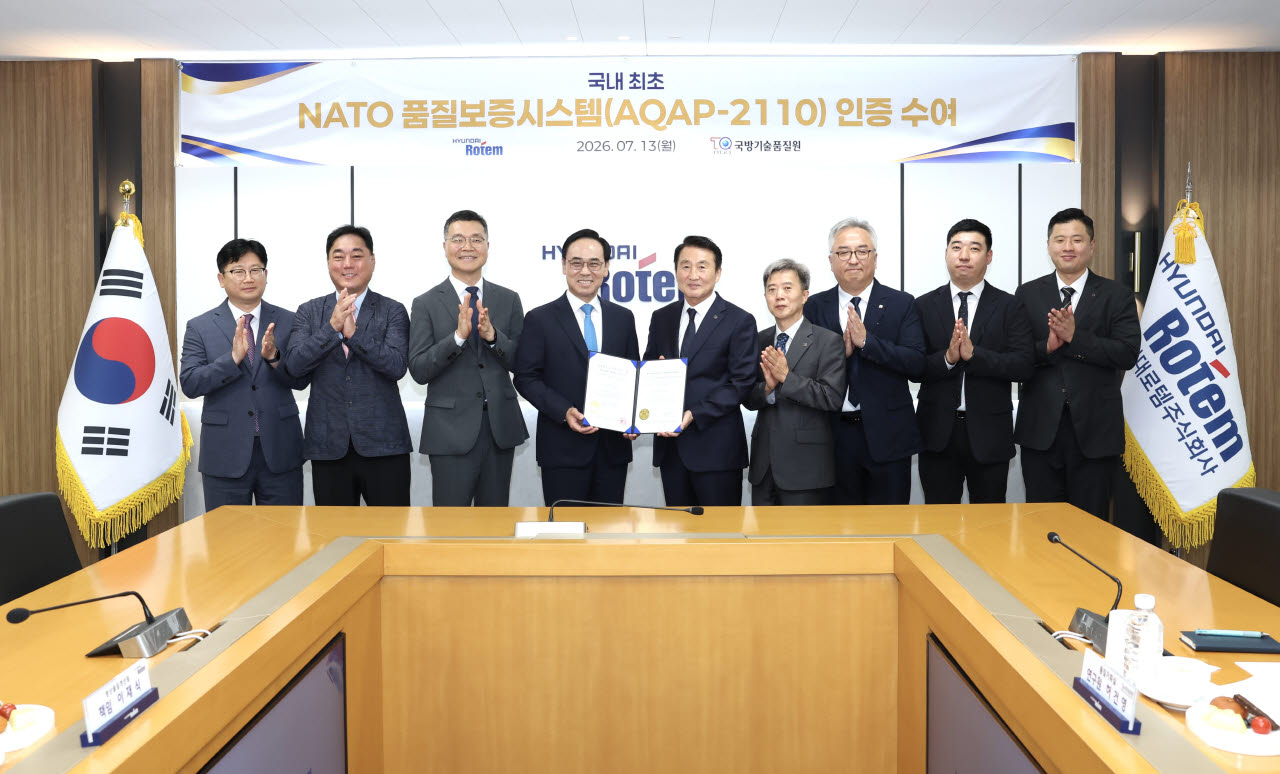 13일 경기도 의왕 현대로템에서 신상범(가운데 오른쪽부터) 국방기술품질원장이 이용배 현대로템 대표이사에게 나토 품질보증시스템(AQAP-2110) 인증서를 수여하고 기념촬영을 하고 있다.