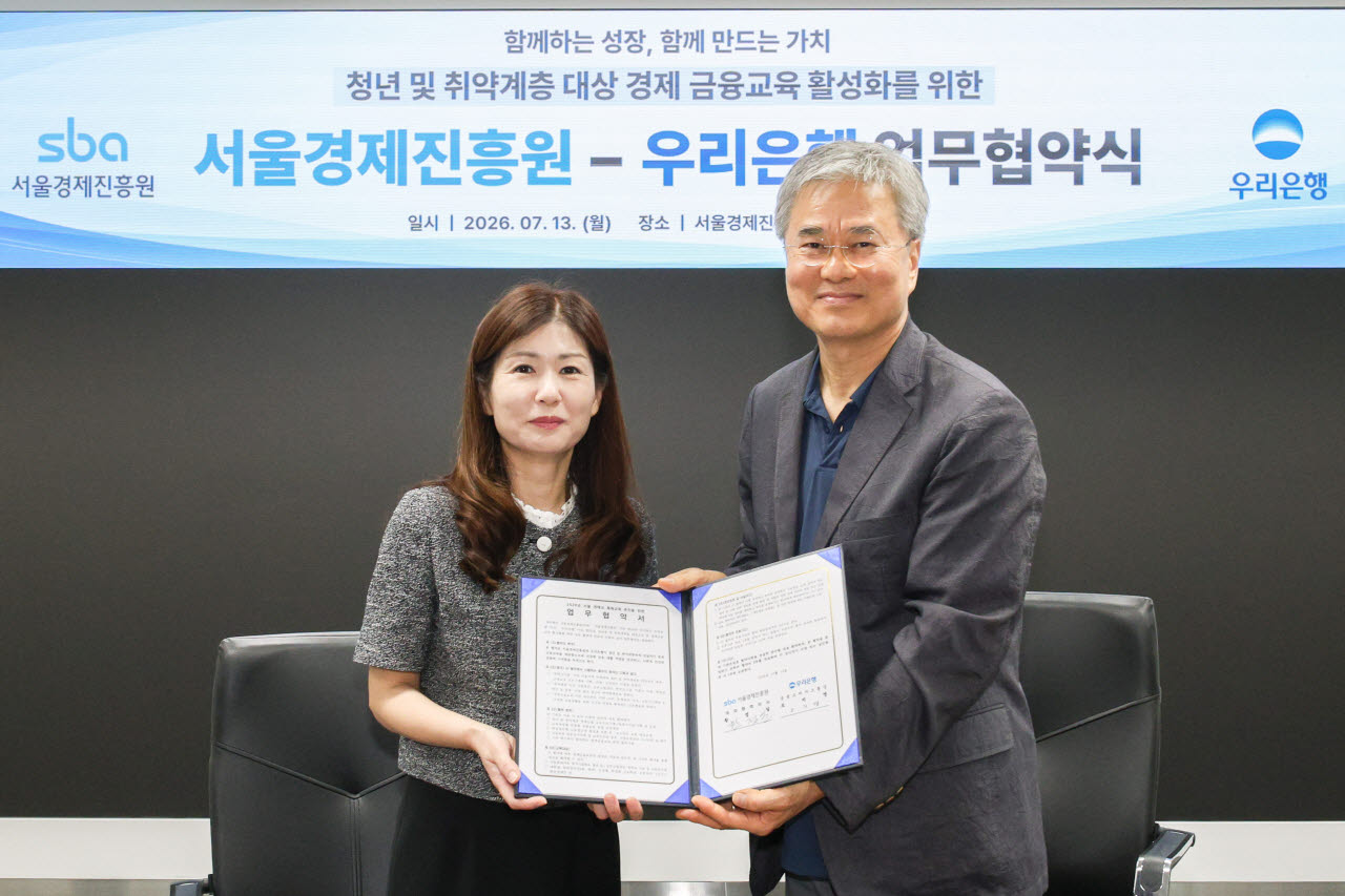 (왼쪽부터) 우리은행 오지영 금융소비자보호그룹장 및 서울경제진흥원 황정일 대외협력이사가 지난 13일 ‘청년 및 취약계층대상 경제 금융교육 활성화를 위한 업무협약’을 체결한 후 기념 촬영을 하고 있다.(사진=우리은행 제공)