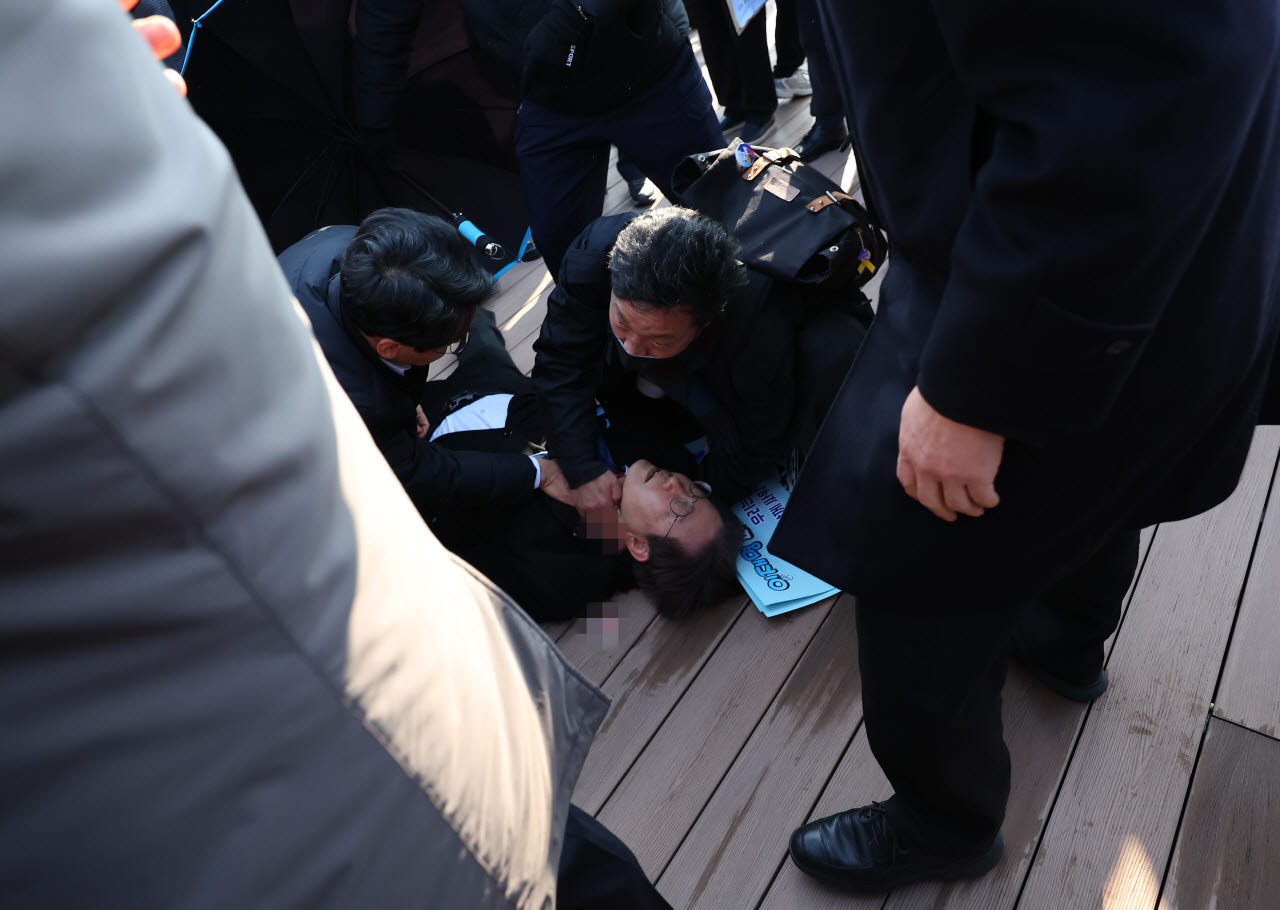 지난 2024년 1월 당시 이재명 더불어민주당 대표가 부산 가덕도 신공항 부지를 둘러본 후 기자들과 문답을 진행하던 중 왼쪽 목 부위에 습격을 당해 피를 흘린 채 쓰러져 있다. (사진=연합뉴스)