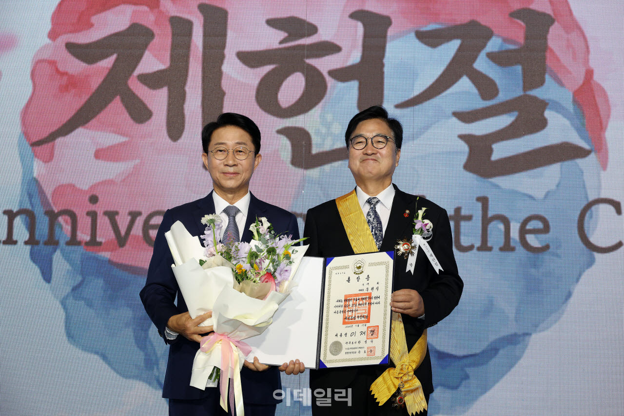 [국회사진기자단] 조정식 국회의장이 17일 서울 여의도 국회에서 열린 제78회 제헌철 경축식에서 우원식 전 국회의장에게 무궁화장을 전수한 뒤 기념 촬영을 하고 있다.