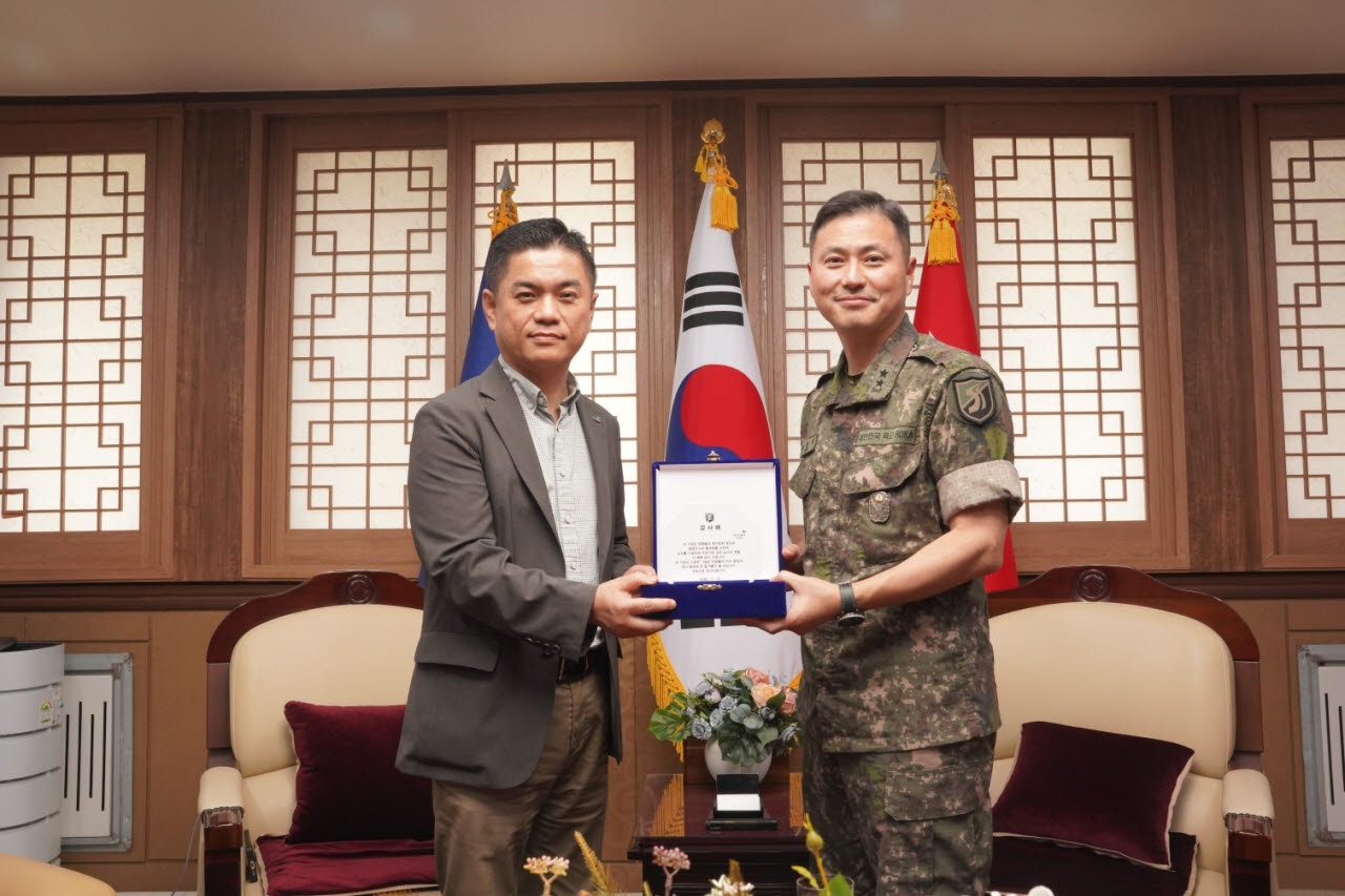 노경주 교보문고 마케팅지원단장(왼쪽)과 우석제 육군 제51보병사단장이 도서 기증식에서 기념촬영을 하고 있다(사진=교보문고).