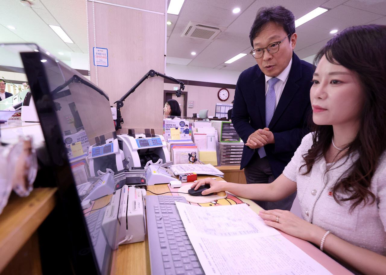 박인환 우정사업본부장(왼쪽)이 20일 오후 은행대리업 시범운영 관서인 청양우체국을 찾아 대출업무 절차 시현 등 현장을 점검하고 있다. (사진=우정사업본부)