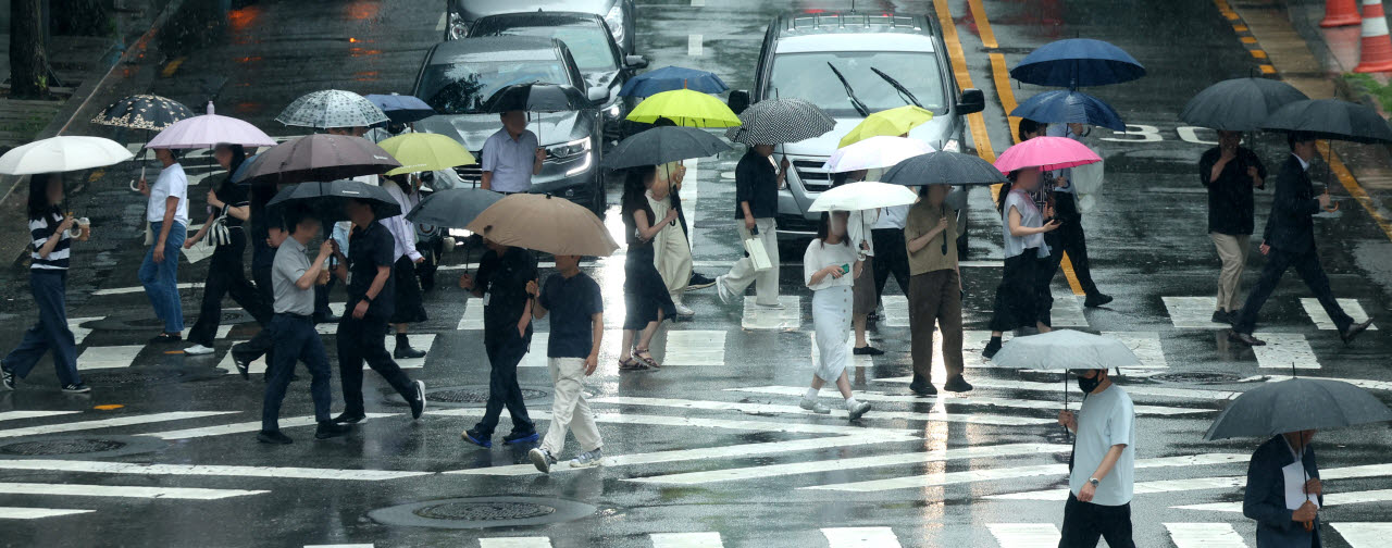 전국에 장맛비가 내리는 20일 오후 서울 종로구 도렴동 횡단보도에서 인근 직장인들이 우산을 쓰고 걸어가고 있다. (사진=뉴시스)