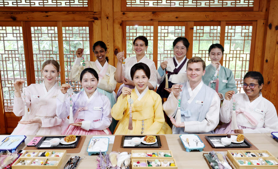 김혜경 여사가 20일 서울 종로구 부암동 무계원 사랑채에서 외국인 청년들과 직접 만든 한국 전통공예 노리개를 들고 기념촬영을 하고 있다.(사진=연합뉴스)