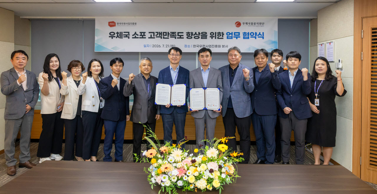 한국우편사업진흥원 송관호 원장(왼쪽)과 우체국물류지원단 오기호 이사장(오른쪽)이 업무협약서에 서명한 후 기념 촬영을 하고 있다. (사진=한국우편사업진흥원·우체국물류지원단)