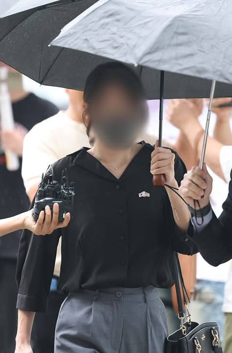 6·3 지방선거 개표소로 사용된 올림픽공원 핸드볼경기장 문 앞에서 체육단체 직원들의 장내 사무실 진입을 막아 업무 방해 혐의를 받는 30대 여성이 21일 구속 전 피의자 심문(영장실질심사)을 위해 서울 송파구 서울동부지법으로 출석하고 있다.(사진=연합뉴스)