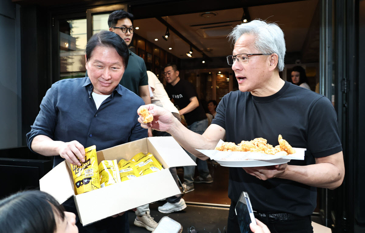 젠슨 황 엔비디아 CEO와 최태원 SK 회장이 지난달 7일 서울 강남구 깐부치킨 삼성점에서 치맥 회동을 하던 중 과자와 치킨을 나눠주고 있다.(사진=연합뉴스)