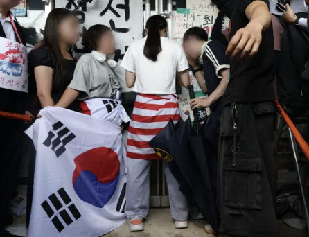 6·3 지방선거 투표용지 부족 사태로 시작한 서울 송파구 올림픽공원 핸드볼경기장 일대 ‘개표소 봉쇄 시위’가 이어진 16일 허리에 태극기를 두른 A씨가가 문을 가로막아 체육단체 직원들이 경기장 안으로 들어가지 못하고 있다. (사진=공동취재사진)