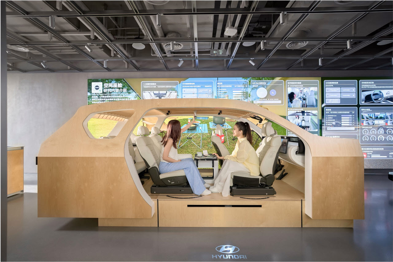 UX 테스트 존에 전시된 나무로 만든 스터디 벅(Study Buck)에서 방문객들이 마주 앉아 대면 모드를 체험하는 모습.