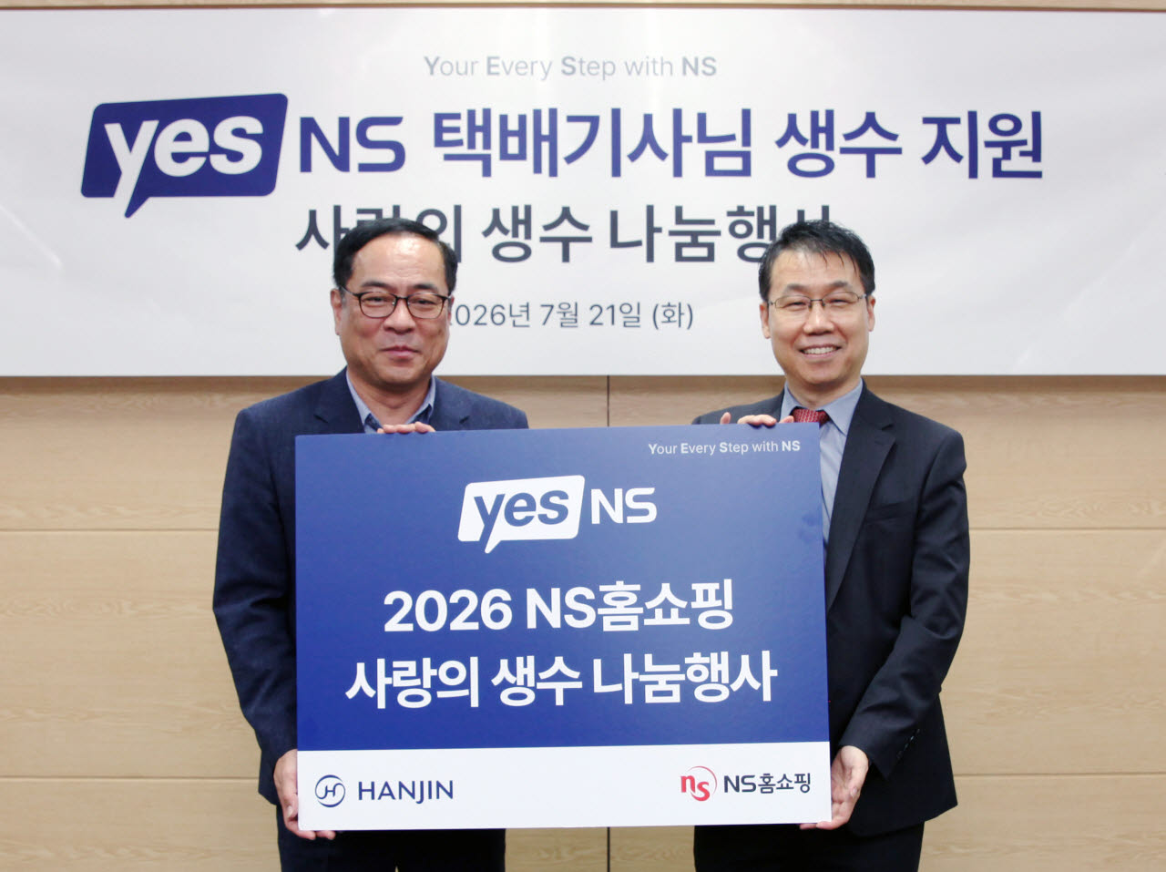 강영철 한진택배 택배영업본부장 상무(왼쪽), 유대희 NS홈쇼핑 고객지원본부 이사가 지난 21일 택배기사들을 위한 ‘사랑의 생수 전달식’기념사진을 찍고 있다. (사진=NS홈쇼핑)