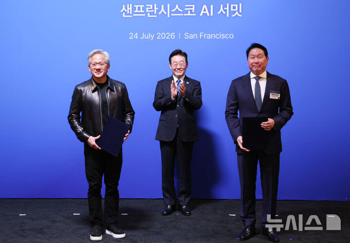 이재명 대통령이 24일(현지 시간) 미국 샌프란시스코 더 미드웨이에서 열린 샌프란시스코 AI 서밋에서 최태원 SK 회장과 젠슨 황 엔비디아 CEO의 ‘전략적 AI 팩토리 및 반도체 협력 MOU(업무협약)’ 체결을 지켜보고 있다. 사진=뉴시스