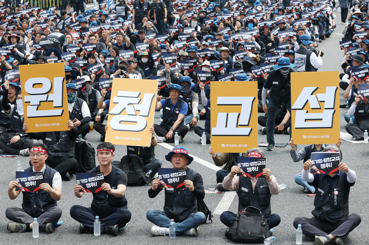 지난 6월 10일 서울 종로구 광화문광장에서 열린 전국금속노동조합 1만 간부 결의대회에서 참가자들이 '원청교섭 쟁취' 손팻말을 들고 있다. (사진=연합뉴스)