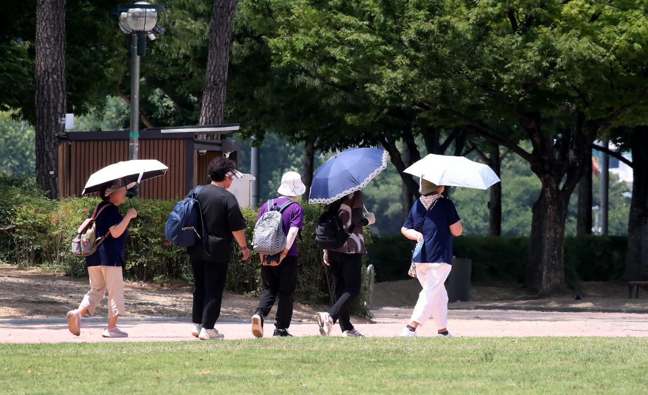 폭염이 계속된 27일 대구 수성구 수성못 상화동산에서 시민들이 뙤약볕을 피하기 위해 양산을 쓴 시민들이 발걸음을 옮기고 있다.(사진=뉴스1)