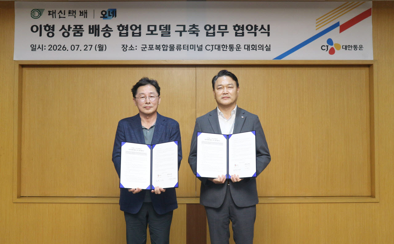 CJ대한통운 군포복합물류터미널에서 27일 진행된 ‘이형 상품 배송서비스 확대 및 협업모델 구축' 업무협약식에 참석한 윤재승 CJ대한통운 오네(O-NE) 본부장(오른쪽), 신창우 대신택배 영업 총괄 부사장이 기념 사진을 촬영하고 있다. (사진=CJ대한통운)