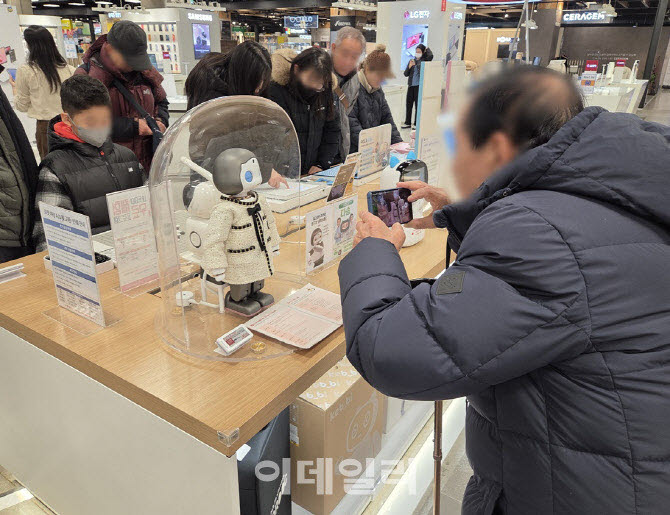 한 고령의 고객이 감정 표현이 가능한 반려로봇을 촬영하고 있다.(사진=이데일리DB)