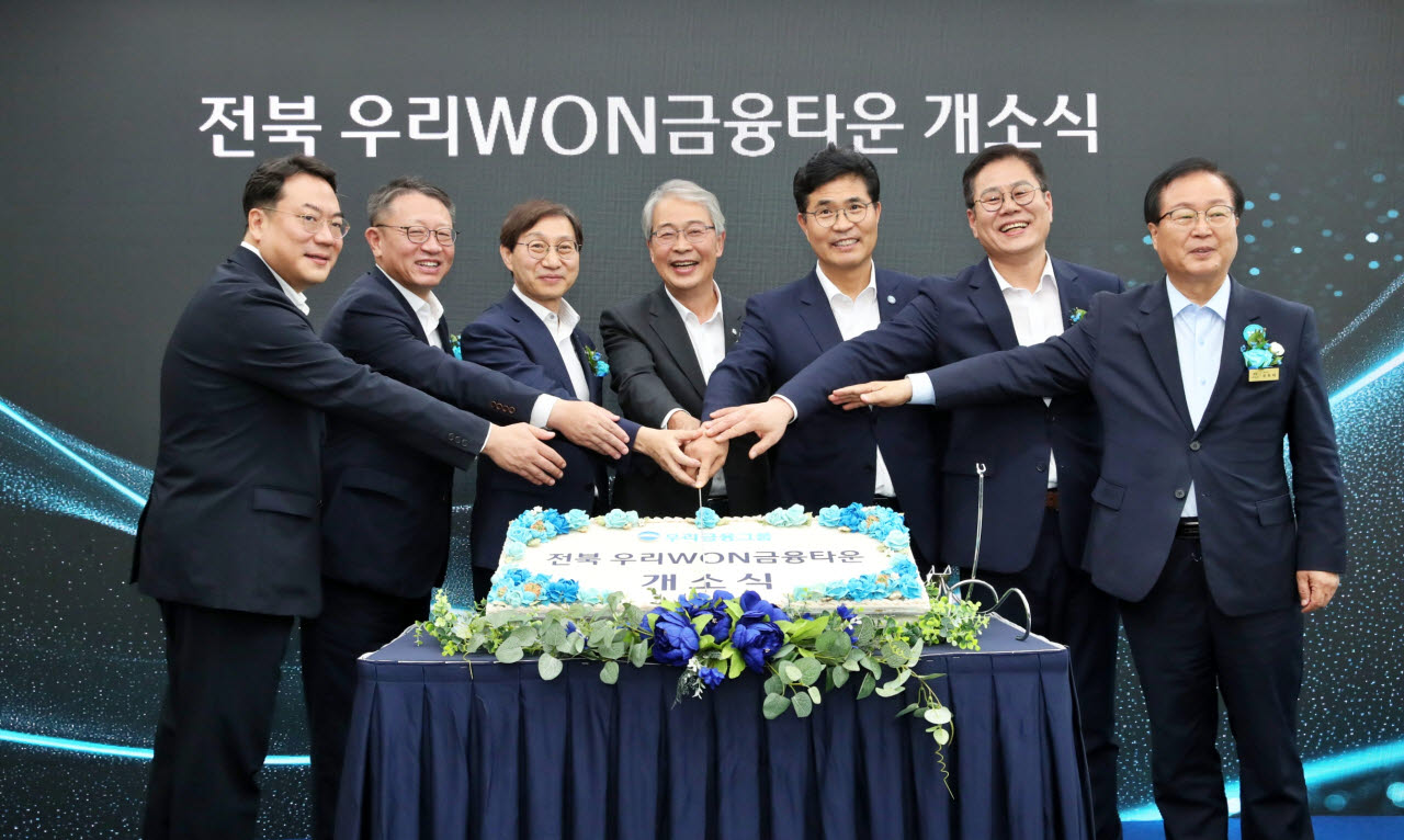 29일 전북혁신도시에서 열린 ‘전북 우리WON금융타운’ 개소식에서 (왼쪽부터)최승재 우리자산운용 대표, 정진완 우리은행장, 김성주 국민연금공단 이사장, 임종룡 우리금융그룹 회장, 이원택 전북특별자치도지사, 조지훈 전주시장, 유희태 완주군수가 개소를 기념하는 세리머니를 하고 있다.(사진=우리금융그룹)
