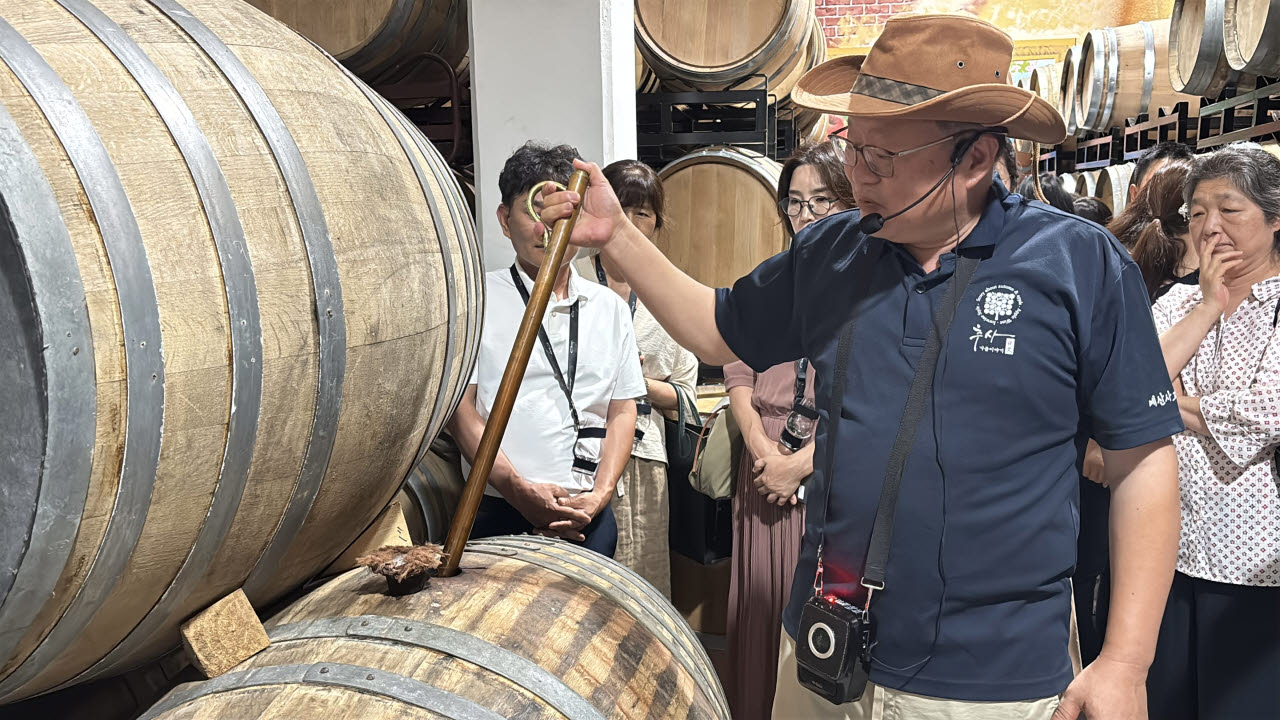 정제민 예산사과와인 대표가 베럴띠프(Barrel Thief)를 이용해 오크통 안에 들어 있는 술을 뽑아 올리고 있다.(사진=조민정 기자)