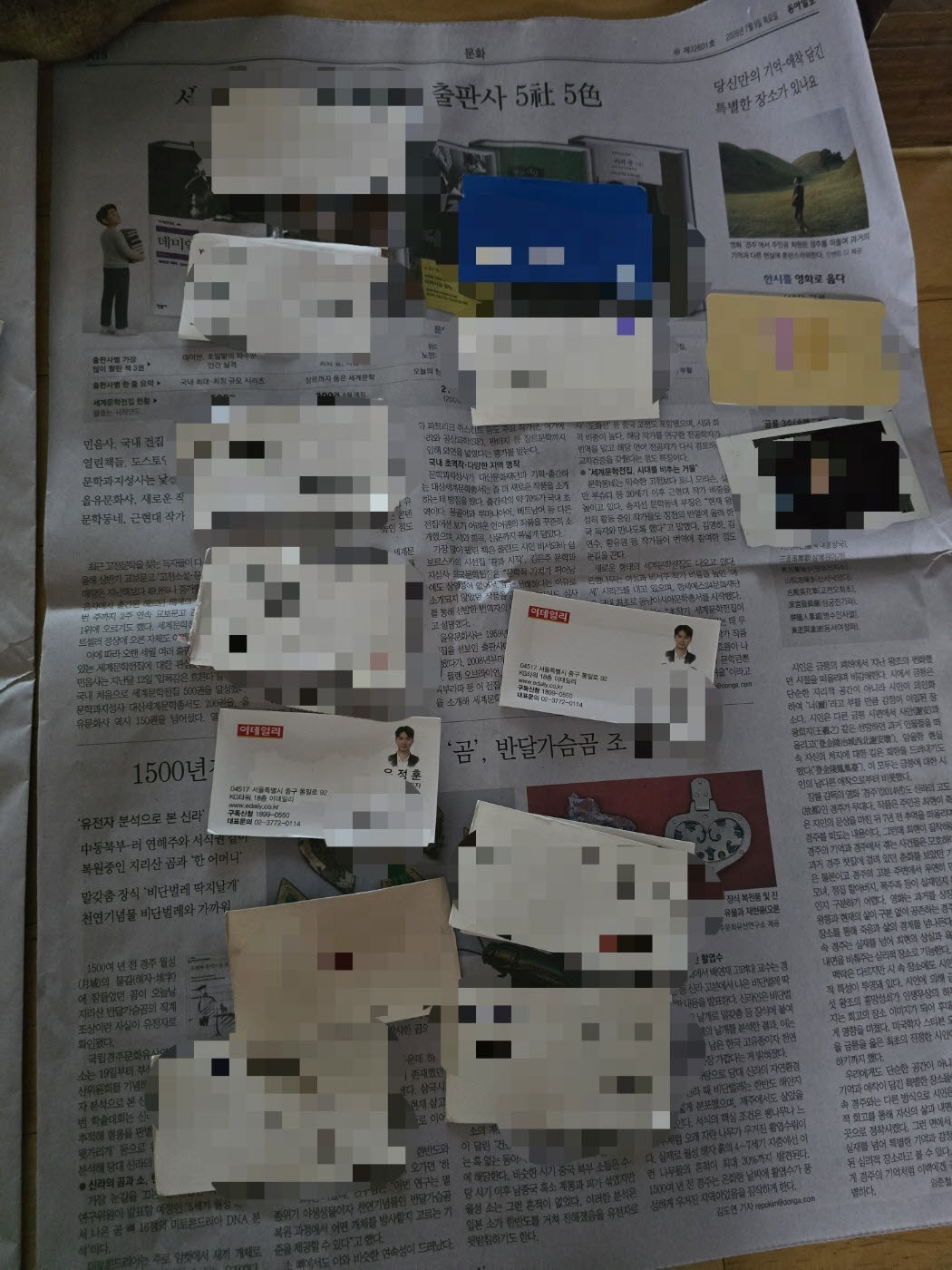 당시 청바지에 들어있던 명함지갑과 명함 등도 젖어서 신문지 위에 같이 건조시키고 있다(사진=윤정훈 기자)