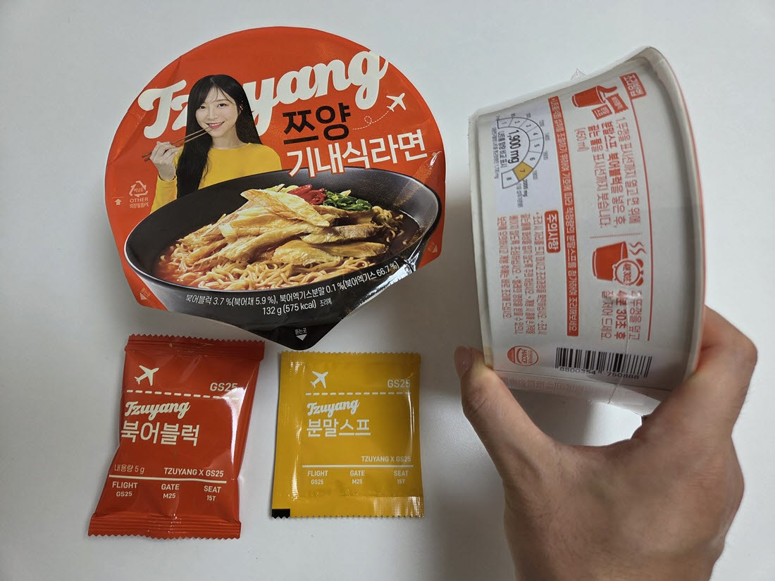GS25 '쯔양 기내식 라면' 제품과 구성품. 항공권을 본뜬 패키지 디자인과 별도 북어블록이 특징이다. (사진=한전진 기자)