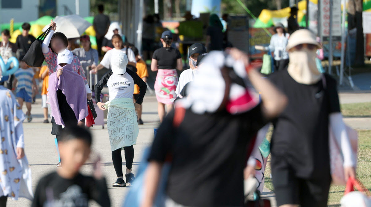 경남 양산시 물금읍 운영이 종료된 황산공원 물놀이장을 나서는 피서객들이 모자와 양산으로 뜨거운 햇빛을 가리고 있다.(사진= 연합뉴스)