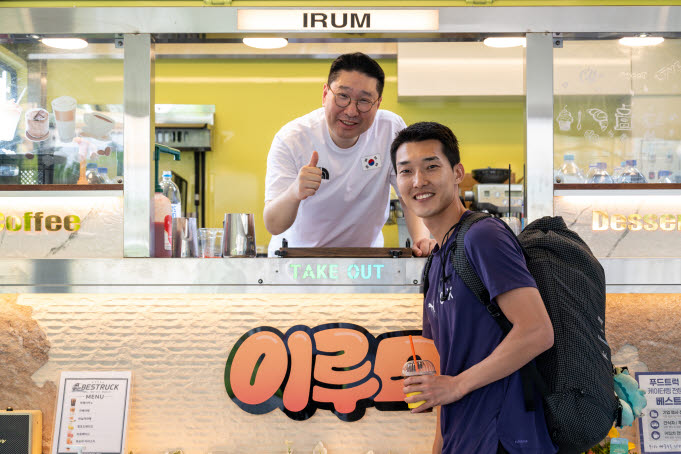 이상현 아이치·나고야 아시안게임 대한민국 선수단장이 커피차에서 한국 높이뛰기 간판스타 우상혁에게 커피를 전달하고 있다. 사진=대한체육회